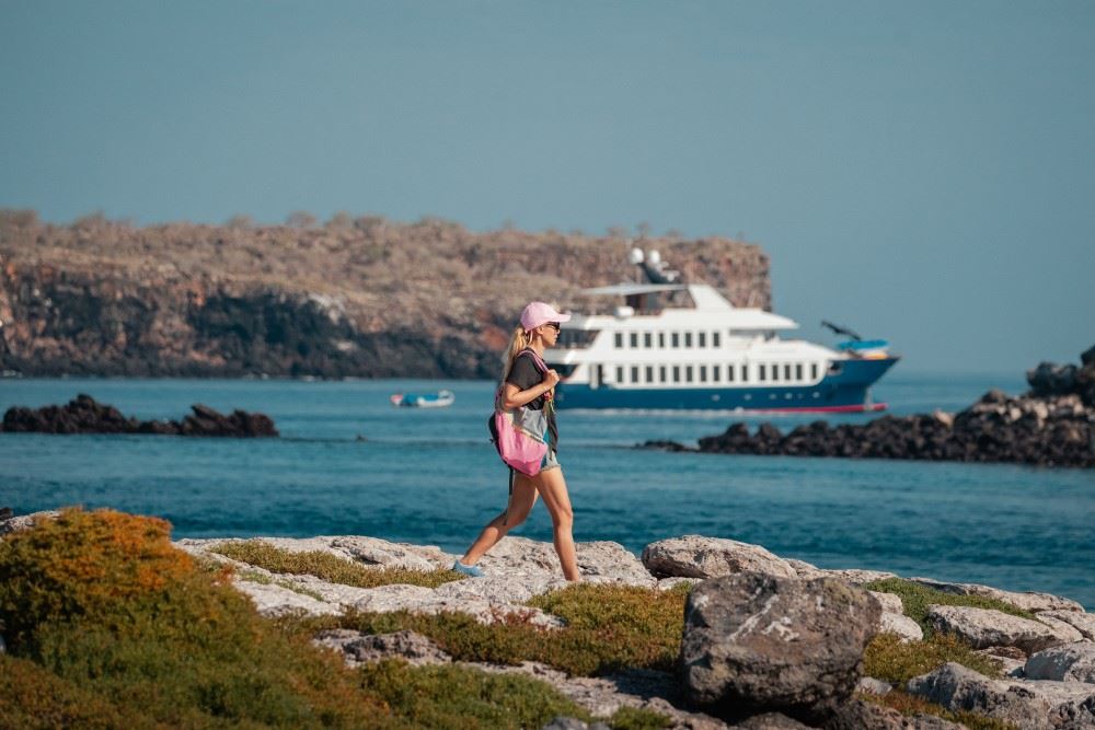 ecoventura yacht in the galapagos with woman walking
