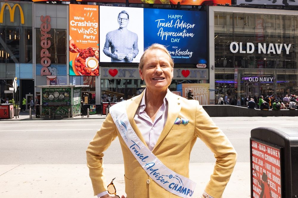 Carson Kressley in front of the travel advisors appreciation billboard in Times Square.