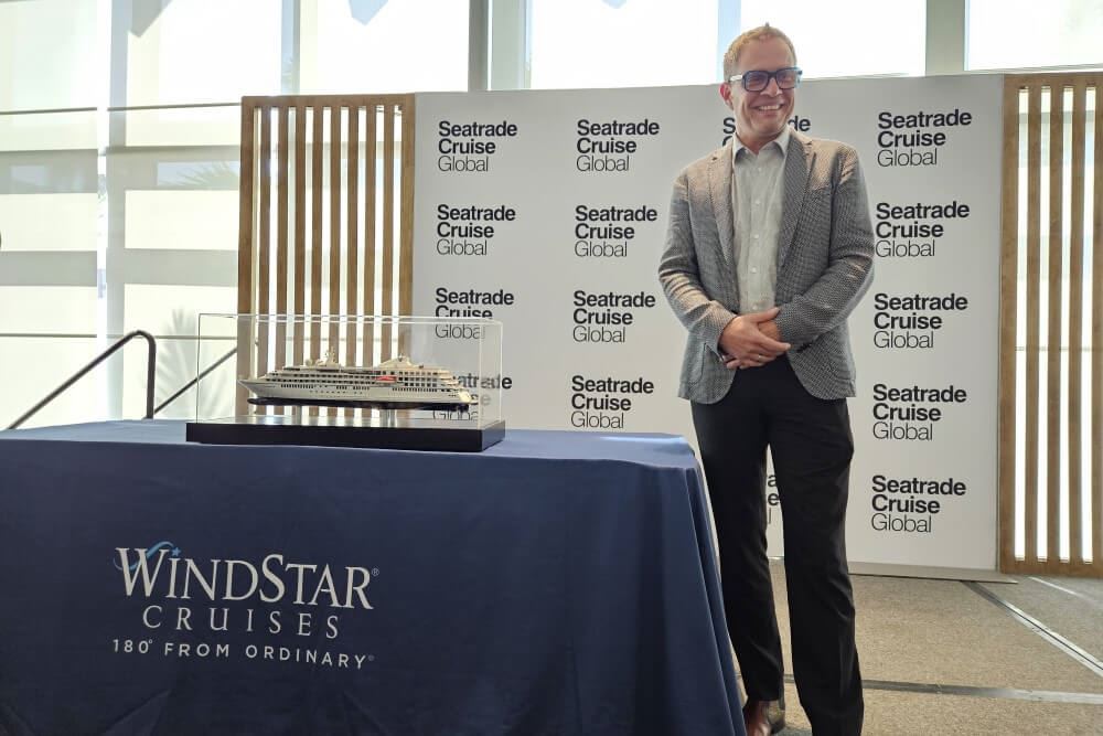 Windstar president Christopher Prelog standing next to a model of Star Seeker