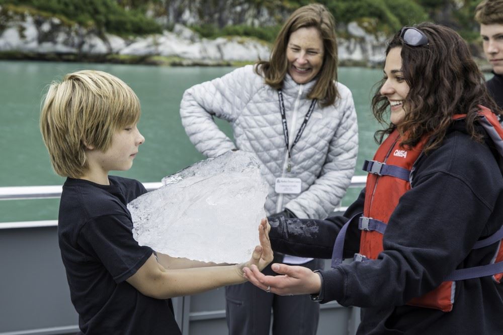 boy and naturalist looking at glacial ice