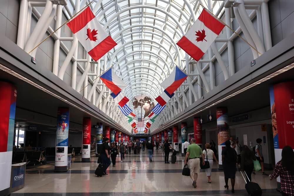 Chicago O'hare Airport inside people walking with flags above
