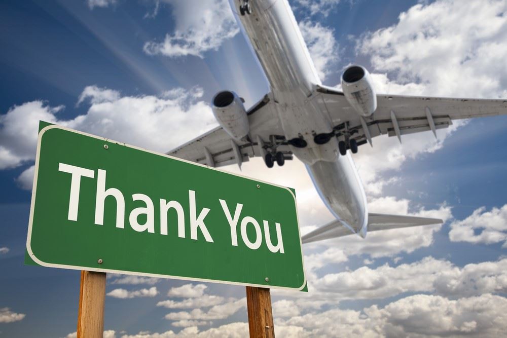 thank you sign with airplane overhead - travel advisor appreciation