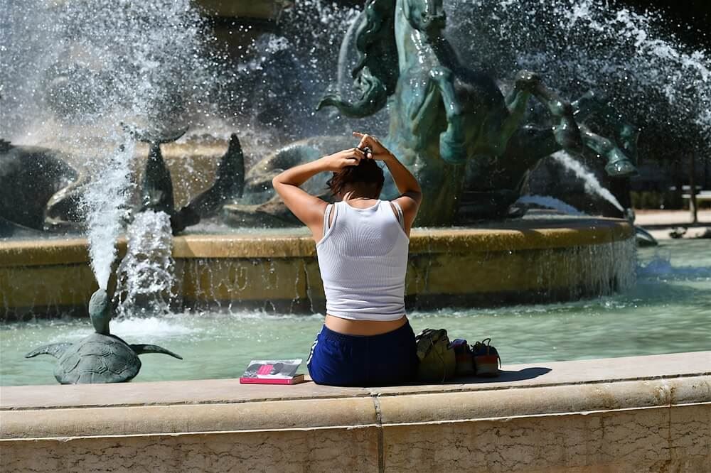 Young tourist soaking herself in a fountain in Paris 