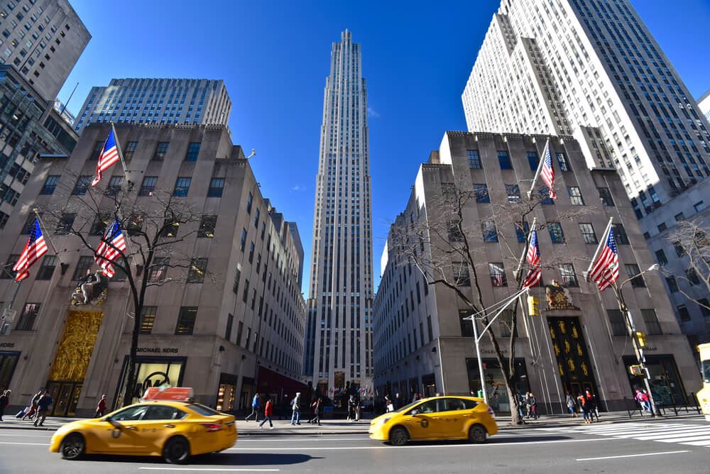Rockefeller Center in New York City with yellow cabs going by 