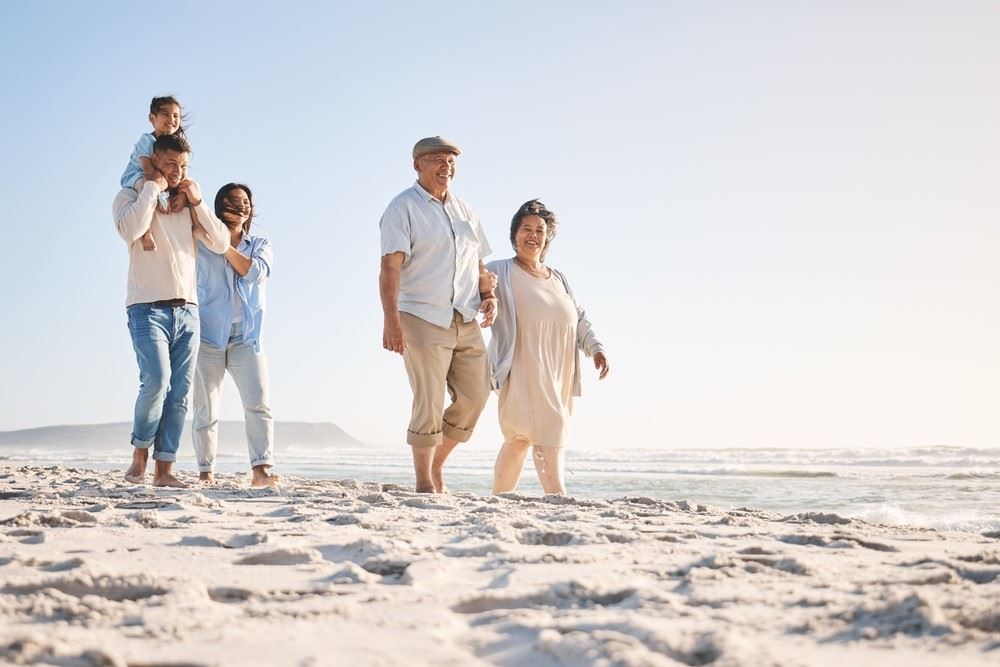 multigenerational family travelers walking on the beach