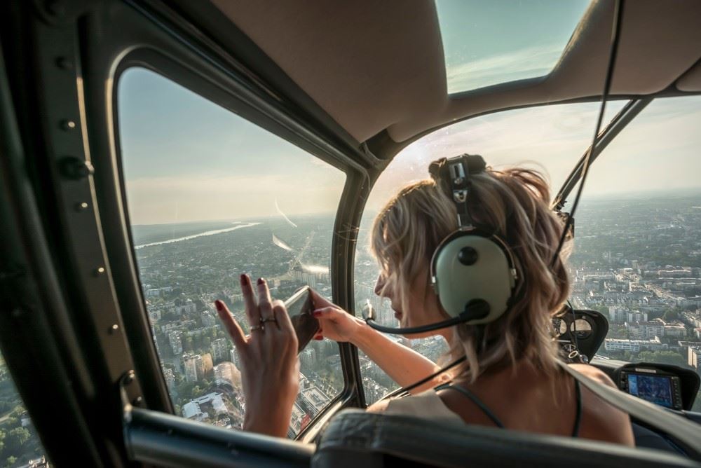 tourist in a helicopter taking a photo of the city below
