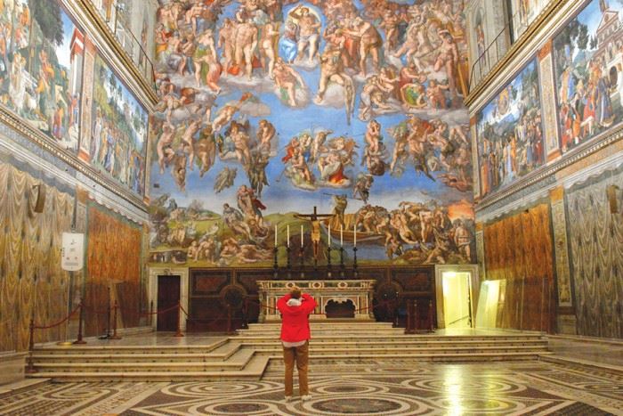 a solo traveler takes a photo of the sistine chapel