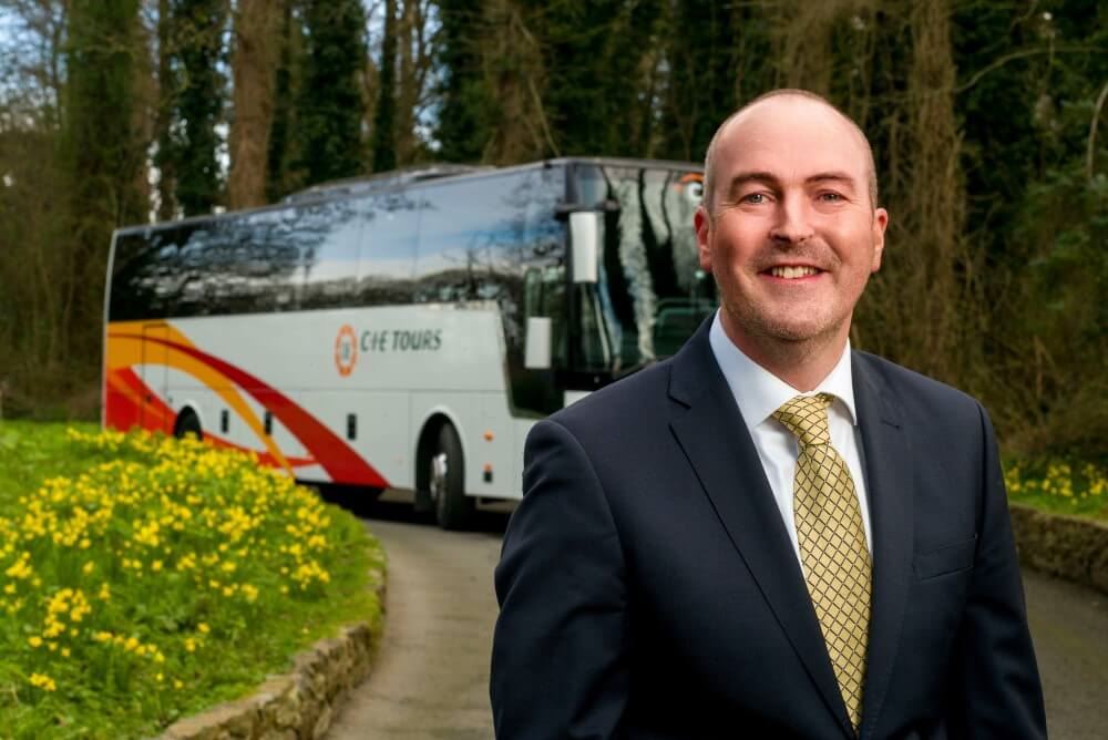 cie tours managing director stephen cotter standing in front of cie tours coach bus
