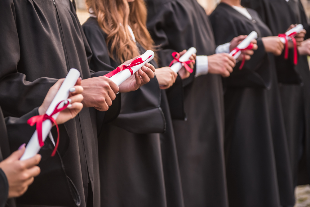 students holding diplomas 