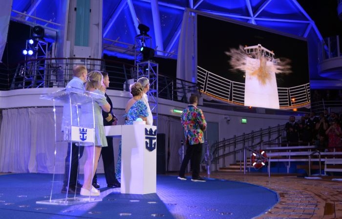 godmother marie mccrea and royal caribbean president michael bayley watch as a champagne bottle smashes against wonder of the seas
