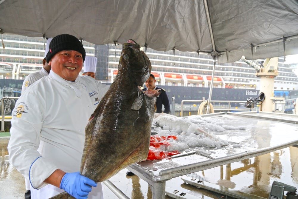 a holland america line chef with a fresh fish delivery in port