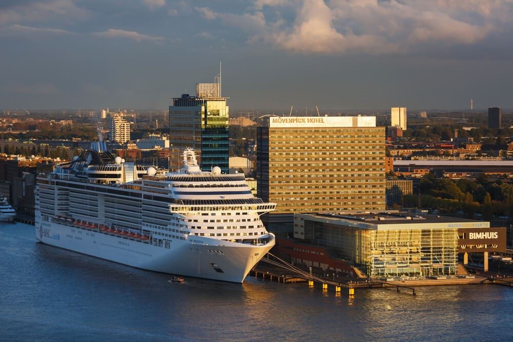 MSC Preziosa cruise ship is moored in a bay of Amsterdam at sunset time