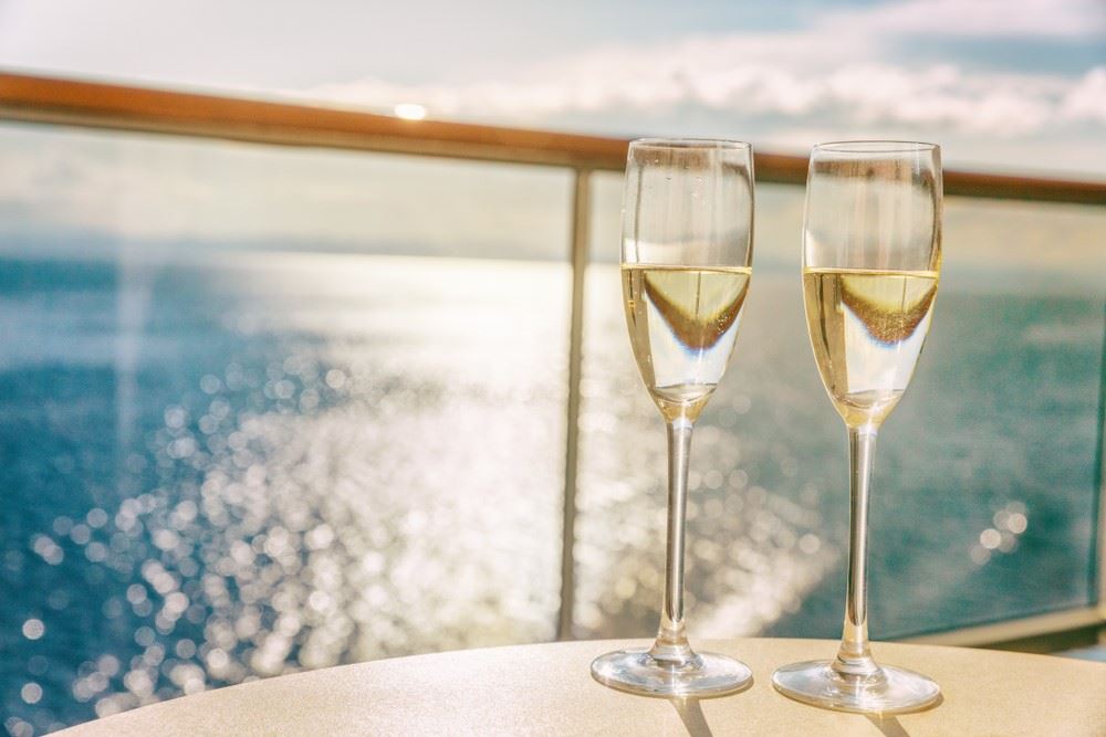 two flutes of champagne on a cruise ship balcony luxury cruising