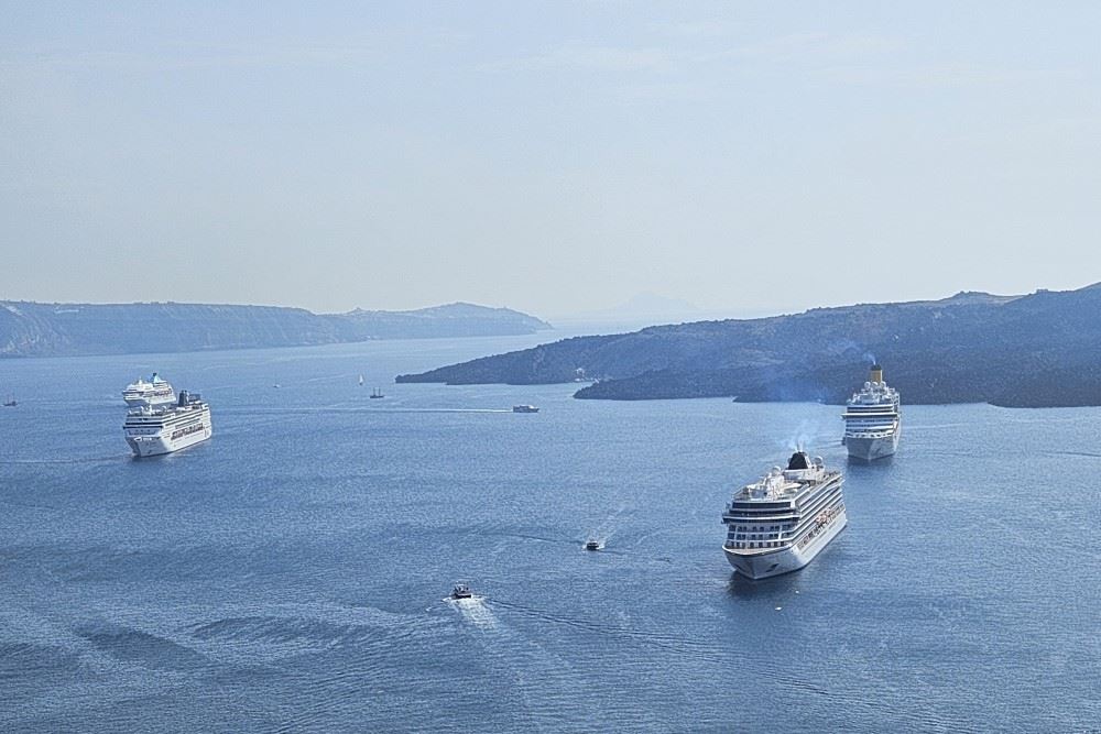 a bunch of cruise ships anchored off of santorini