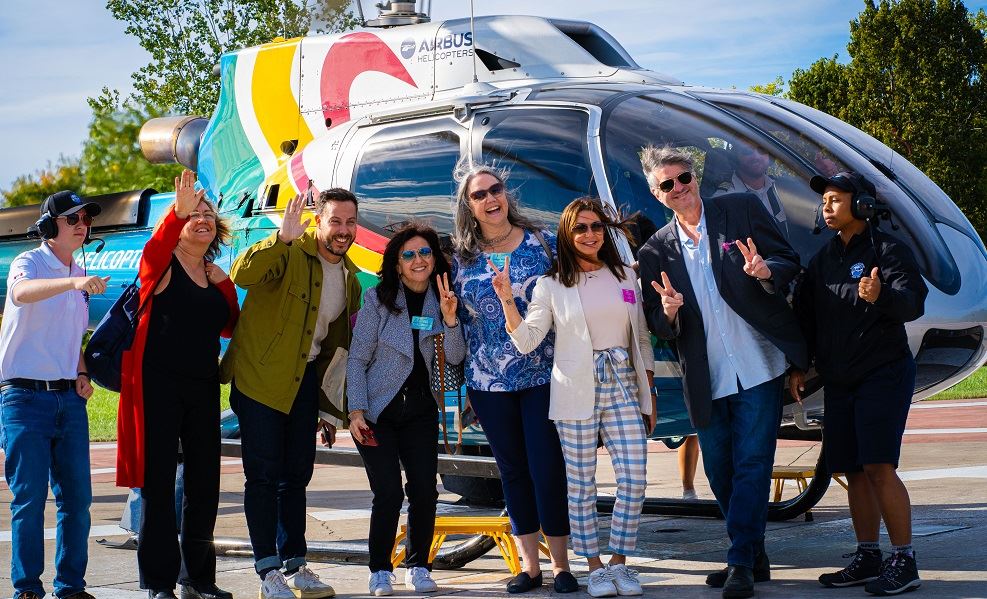 Journeys Event with travel advisors in front of helicopter 