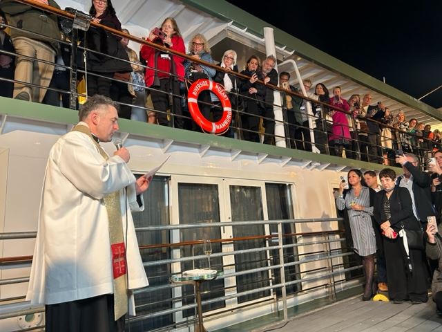 a priest blesses riverside mozart on the danube river