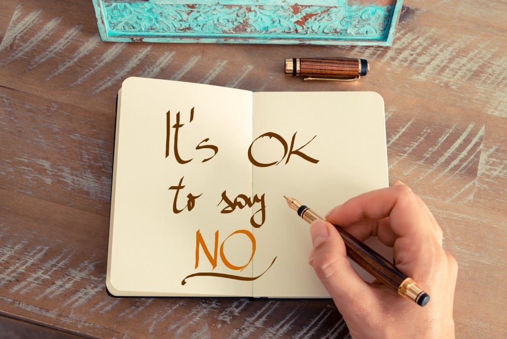woman writing it's okay to say no to business in journal